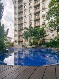 a building with a swimming pool in front of a building at PRIMEHOMES Cozy Condo with Kitchen Utensils in Manila