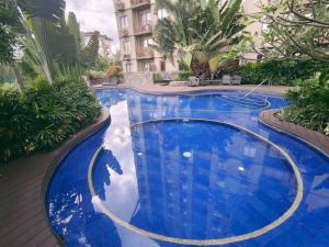 a large pool with blue water in a building at PRIMEHOMES Cozy Condo with Kitchen Utensils in Manila