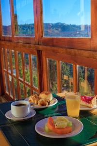 uma mesa com pratos de comida e uma chávena de café em Summit Suítes Hotel Campos do Jordão em Campos do Jordão