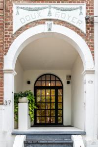 un arco que conduce a una puerta a un edificio en Doux Foyer, en De Haan
