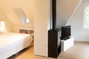 a bedroom with a bed and a brick wall at Doux Foyer in De Haan