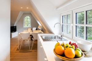 una cocina con un bol de fruta en una barra en Doux Foyer en De Haan