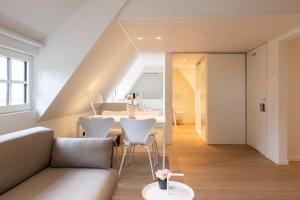 a living room with a couch and a table at Doux Foyer in De Haan