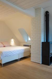 a bedroom with a bed and a brick wall at Doux Foyer in De Haan