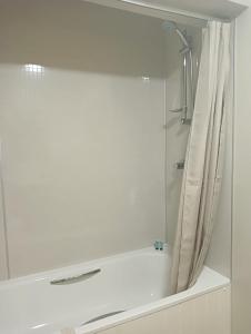 a bathroom with a shower curtain and a sink at Barchester House Apartment Standard in Salisbury