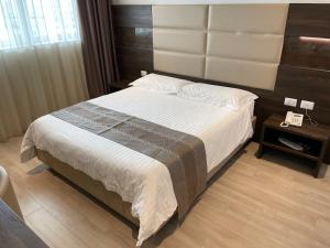 Schlafzimmer mit einem großen Bett mit einem Kopfteil aus Holz in der Unterkunft HotelLuxuryPrato in Prato