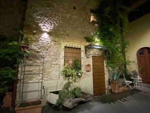 een stenen gebouw met een deur en enkele planten bij casatorre medioevale in Campi Bisenzio