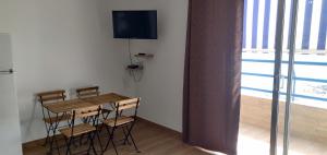 a room with a table and chairs and a television at Estudio Paradise View - Playa Paraíso Tenerife in Adeje
