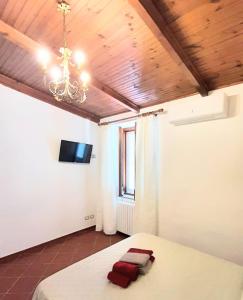 a bedroom with a bed with a chandelier and a window at Casale Battaglini in Castelnuovo Cilento