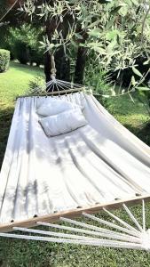 a white hammock bed in the grass in a yard at Casale Battaglini in Castelnuovo Cilento