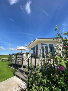 ein weißes Haus mit einer Veranda und einem Sonnenschirm in der Unterkunft East kitcham lodge in Launceston