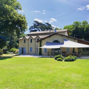 una casa grande con un gran césped delante de ella en Maison de campagne, en Le Temple-sur-Lot