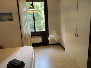 um quarto com uma cama, uma janela e uma mesa em 120 mq vicino a Banca Mediolanum e ospedale Humanitas em Basiglio