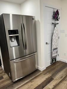a kitchen with a stainless steel refrigerator in a room at Modern Suite by Spruce Meadows in Calgary