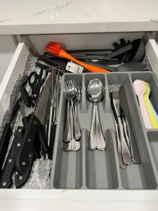 a drawer filled with utensils in a kitchen at Modern Suite by Spruce Meadows in Calgary
