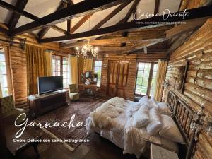 a bedroom with a large bed in a log cabin at Hotel Boutique Casona Oriente in De Cauquenes