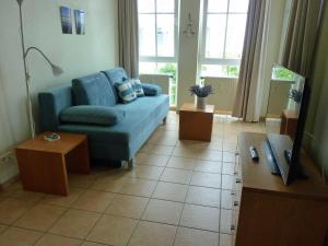 a living room with a blue couch and a table at Meer Urlaub 625 SEEPARK Sellin mit BALKON in Ostseebad Sellin