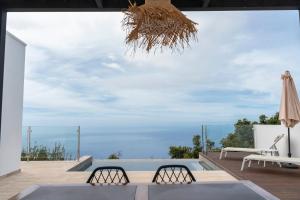 un patio con 2 sillas, una mesa y una sombrilla en Casa Jade, La Palma, en Tijarafe