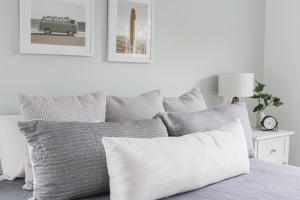 Dormitorio blanco con cama con almohadas grises en 9 Palms, en Myrtle Beach