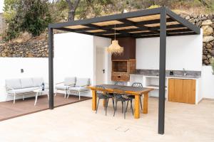 un patio abierto con mesa de madera y sillas en Casa Jade, La Palma, en Tijarafe