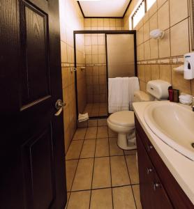 a bathroom with a toilet and a sink at Hotel y Restaurante El Guarco in Cartago