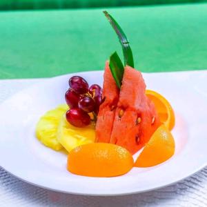 um prato branco com fruta sobre uma mesa em EQUINE RESORT em Gitura