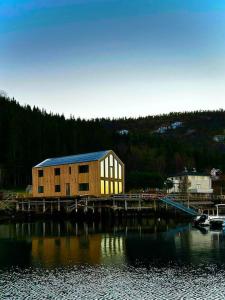 a building on a dock next to a body of water at Nordic Waterside Escape in Ulvsvåg