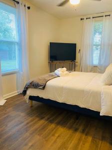 a bedroom with a bed and a flat screen tv at The Grayson Home 3 bedroom 1 bath in New Albany