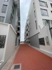 a red brick walkway between two white buildings at (T) Exclusivo departamento en Piura in Piura