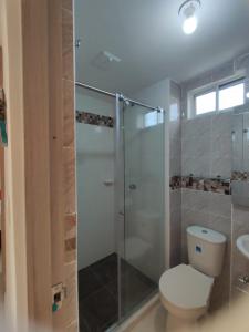 uma casa de banho com um WC e uma cabina de duche em vidro. em apartamento1108 em Cartagena das Índias
