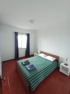 Lajes das FloresにあるOCEANVIEWのベッドルーム1室(緑のシーツが敷かれたベッド1台、窓付)