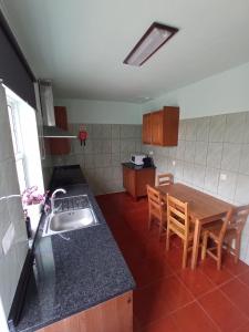 a kitchen with a sink and a table with chairs at OCEANVIEW in Lajes das Flores +3 photos