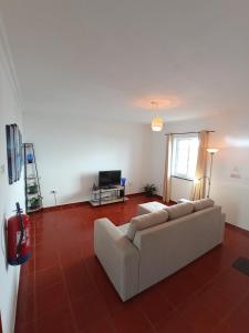 a living room with a couch and a tv at OCEANVIEW in Lajes das Flores