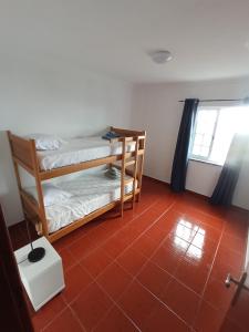 Lajes das FloresにあるOCEANVIEWの赤いタイルフロアの客室で、二段ベッド2組が備わります。