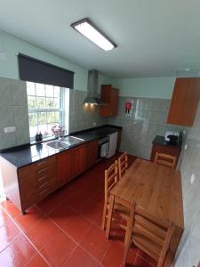 a kitchen with a wooden table and a counter top at OCEANVIEW in Lajes das Flores