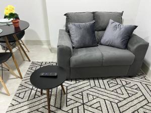 uma sala de estar com um sofá cinzento e uma mesa em Apart Hotel Neri em Sinop