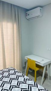 um quarto com uma secretária, uma mesa e uma cadeira amarela em Apart Hotel Neri em Sinop