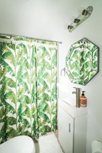 a bathroom with a shower with a green leafy shower curtain at La Casa de Vida Natural in Rio Grande