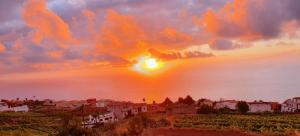 a sunset over a town on the shore of the water at Villa La Casita. in La Matanza de Acentejo