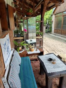 un patio avec un banc et une table avec des plantes en pot dans l'établissement Apartments Bakine Čarolije, à Karanac