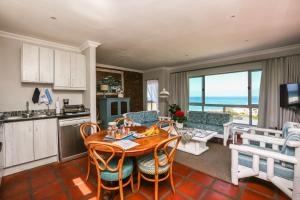 a kitchen and living room with a table and chairs at Imberbe in Struisbaai