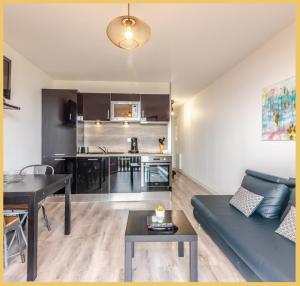 a living room with a blue couch and a table at Appartement T2 Vue Lac Léman Evian les Bains in Évian-les-Bains