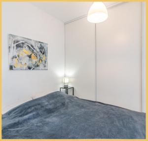 Appartement T2 Vue Lac Léman Evian les Bains في إيفيان لي بان: غرفة نوم بسرير ودهان على الحائط