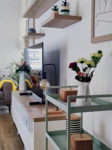 Una habitación con un escritorio con flores. en Caruso apartment en Tivat