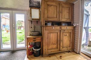 een keuken met houten kasten en een wastafel bij Zimmer in Ferienhäusschen am See / Karstädt in Karstädt