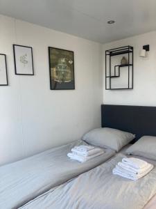 a bedroom with two beds with towels on them at Houseboat De Amstel in Monnickendam