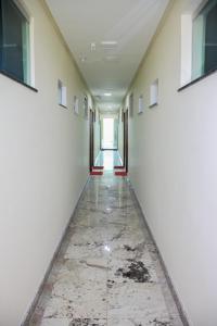um corredor vazio num edifício com piso em mármore em Domus Hotel Palmeiras Canaã dos Carajás em Canaã dos Carajás