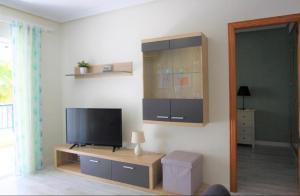 uma sala de estar com uma televisão de ecrã plano na parede em Apartamento Arenales del sol em Arenales del Sol