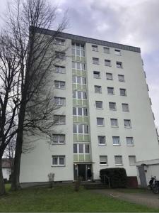 een groot wit gebouw met een boom ervoor bij Offenburg Apartment in Offenburg