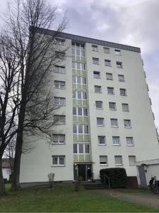 a large white building with a tree in front of it at Offenburg Apartment in Offenburg +4 photos